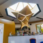 Bar moderno con struttura dorata e luminosa.