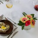 Atmosfera raffinata con ostriche e fiori.