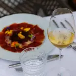 Elegante carpaccio e vino al sole.