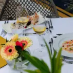 Pranzo raffinato all'aperto con piatti eleganti.
