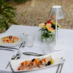 Elegante tavola esterna con piatti gourmet.