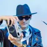 Uomo elegante con macchina fotografica vintage.